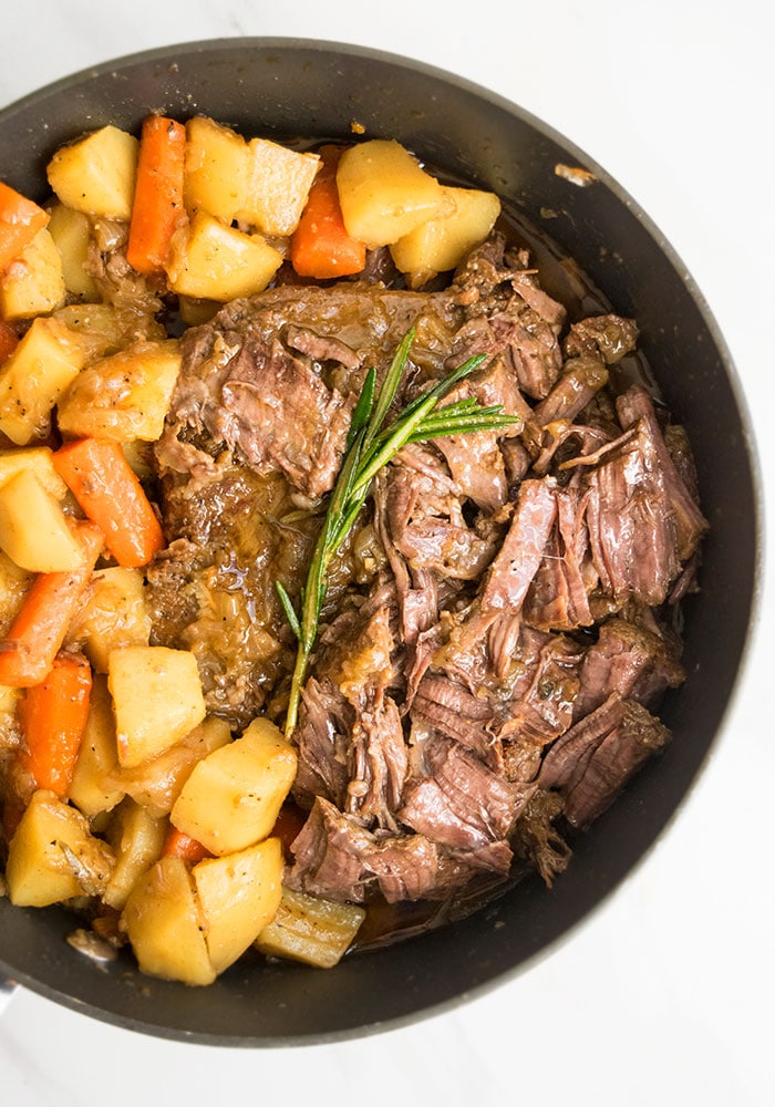 Easy One Pot Stovetop and Oven Pot Roast on White Marble Background.