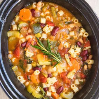 Easy Slow Cooker Minestrone Soup on Wood Background.