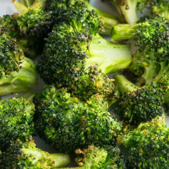 Easy Garlic Parmesan Oven Roasted Broccoli on White Dish.