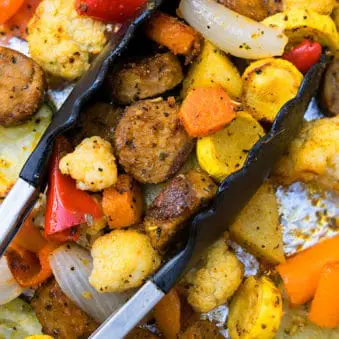 Easy One Pan Sausage and Vegetables in Sheet Pan With Tongs.