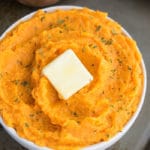 Easy One Pot Mashed Sweet Potatoes With Slices of Butter in White Bowl.