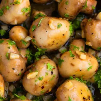 Easy Sauteed Garlic Mushrooms With Parsley in Black Pot.