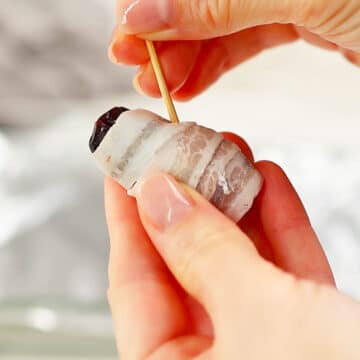 Topping on date being secured with toothpick.