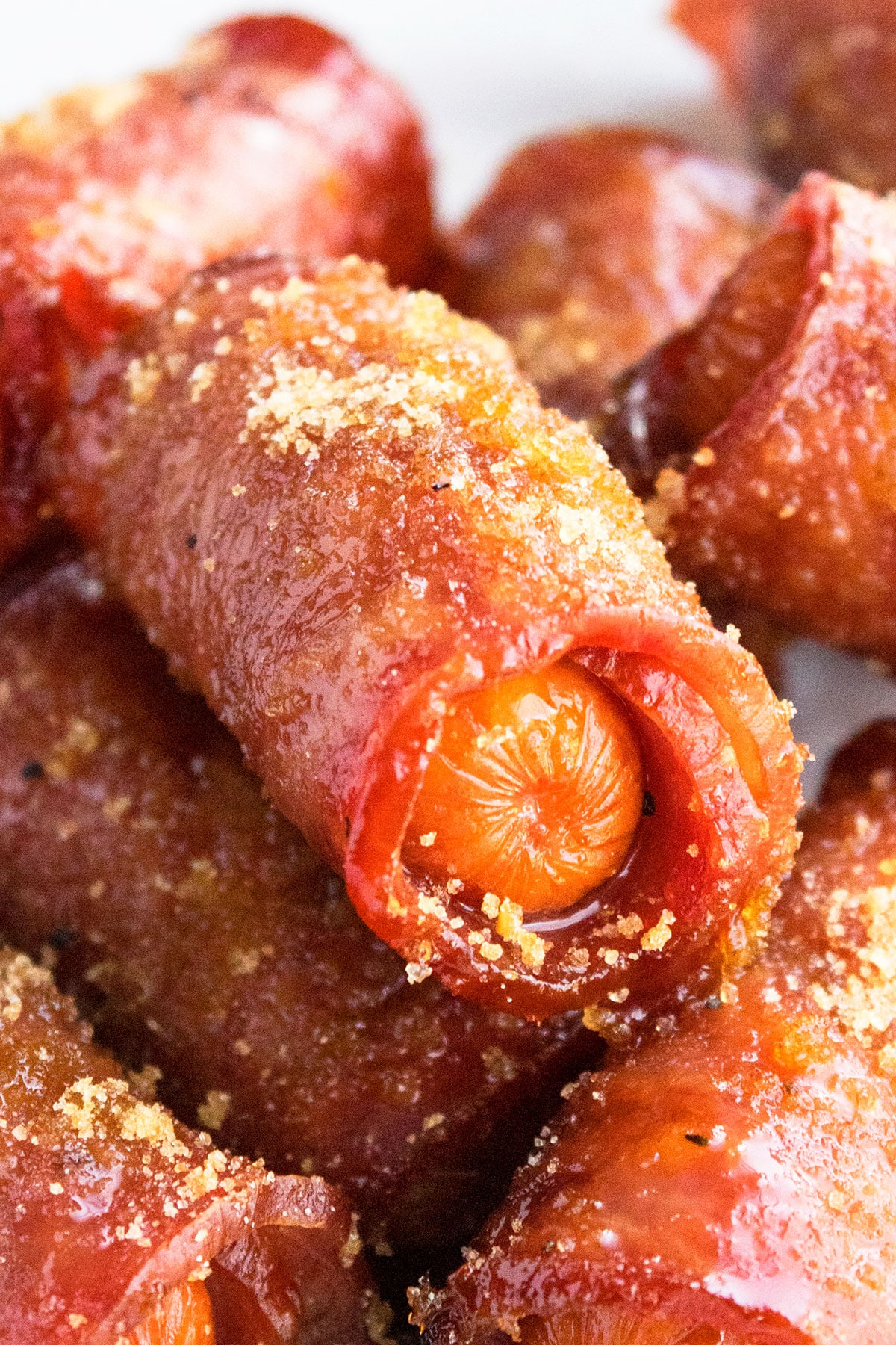 Easy Crispy One Pan Bacon Wrapped Smokies with Brown Sugar in White Dish- Closeup Shot. 