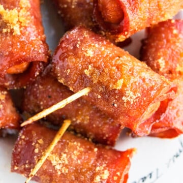Easy Crispy One Pan Bacon Wrapped Smokies with Brown Sugar in White Dish- Closeup Shot.