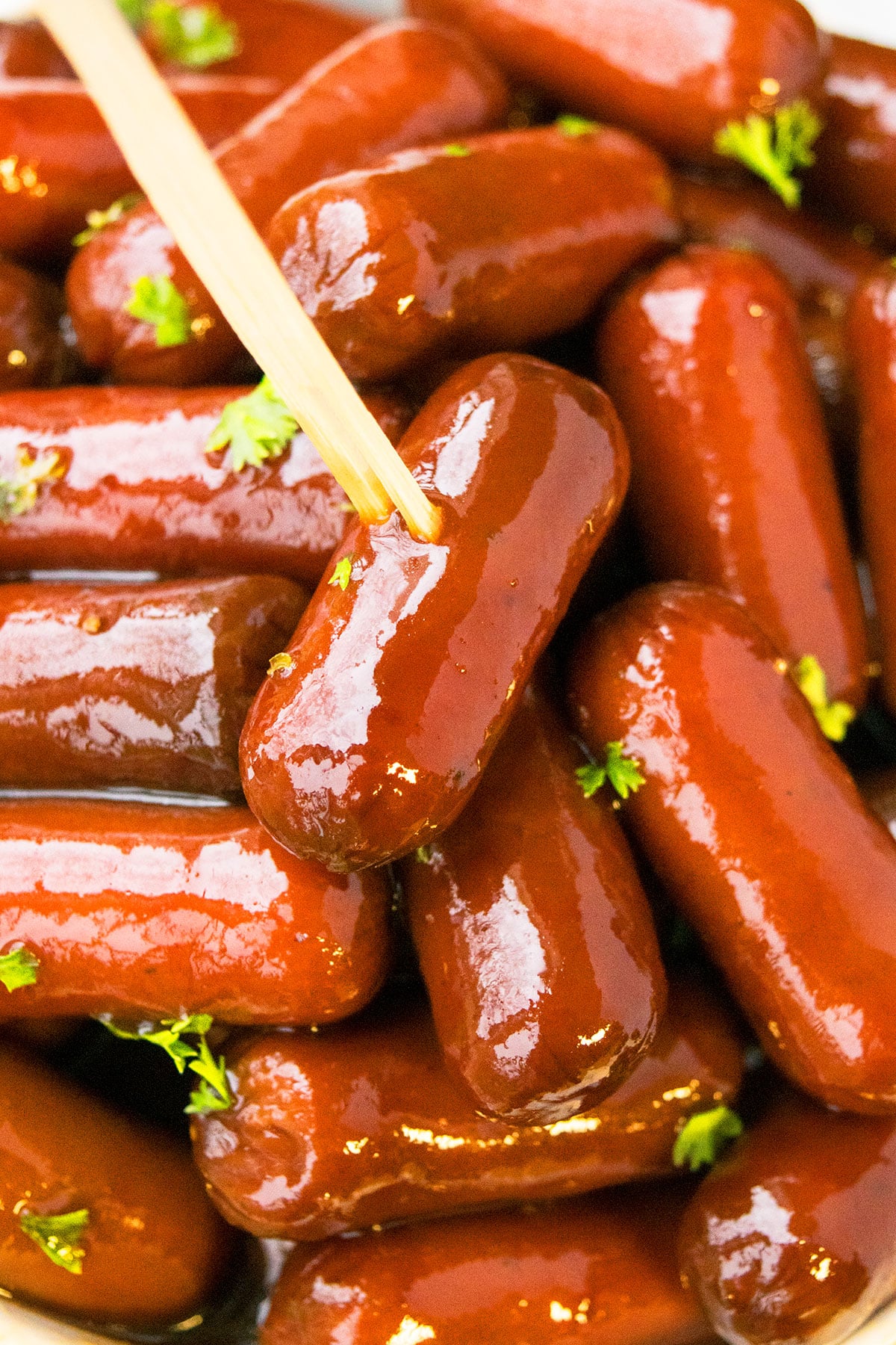 Toothpick attached to mini sausages with bbq grape jelly sauce.