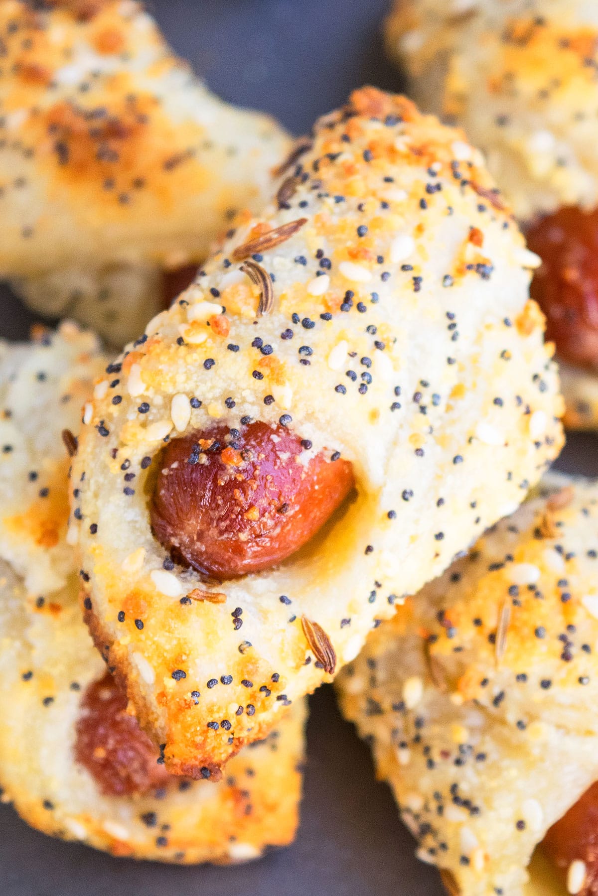 Stack of easy homemade pigs in a blanket on baking tray.