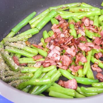 Cooked bacon and spices added to sauteed beans. 