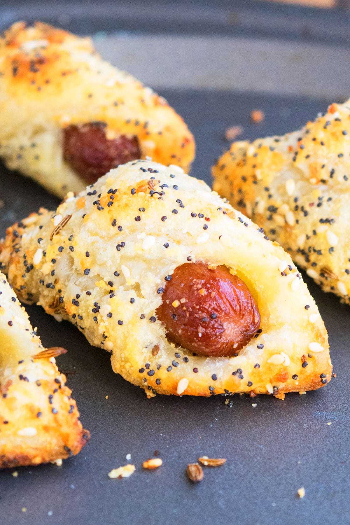 Closeup shot mini sausage puff pastry appetizer on baking tray.