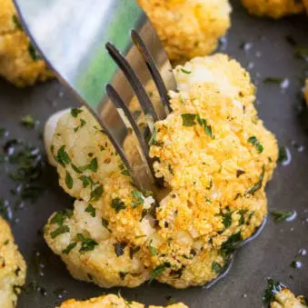 Fork Full of One Pan Crispy Oven Roasted Cauliflower on Baking Tray.