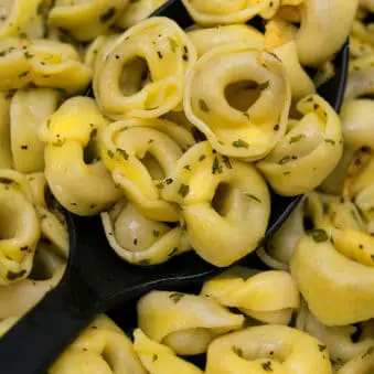 Large Spoonful of One Pot Cheese Tortellini Recipe with Garlic Butter Sauce.