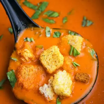 Ladle Full of Easy Roasted Red Pepper Soup- Closeup Shot.