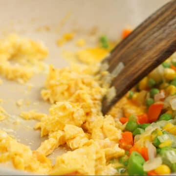 Eggs being scrambled in a nonstick pan.