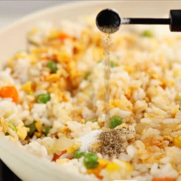 Spices being added to rice mixture.