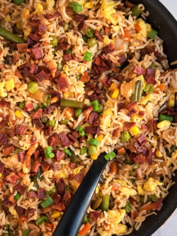 Best easy one pot bacon fried rice in nonstick pan with black spoon- Overhead shot.