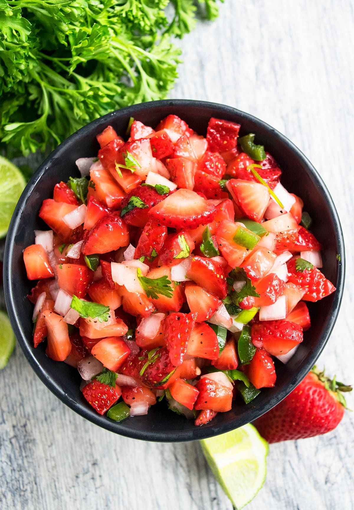 Easy strawberry salsa in black bowl- Overhead Shot. 