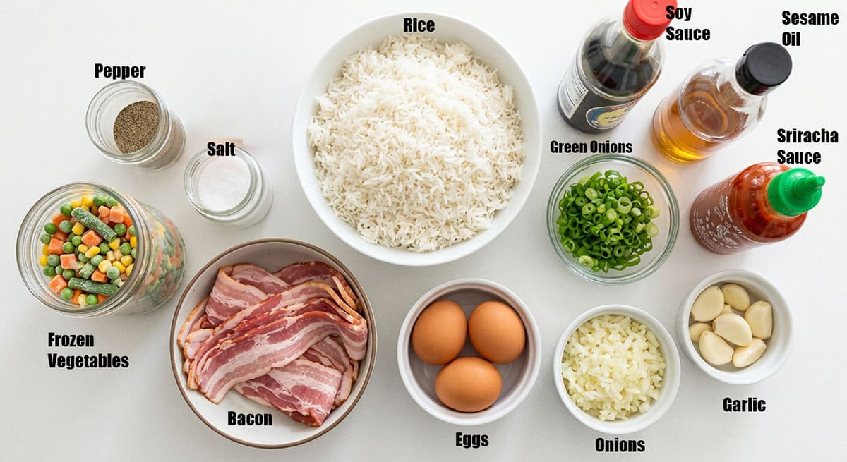 ingredients for recipe on white background- Spices, vegetables, rice, eggs, bacon, sauces, oil.