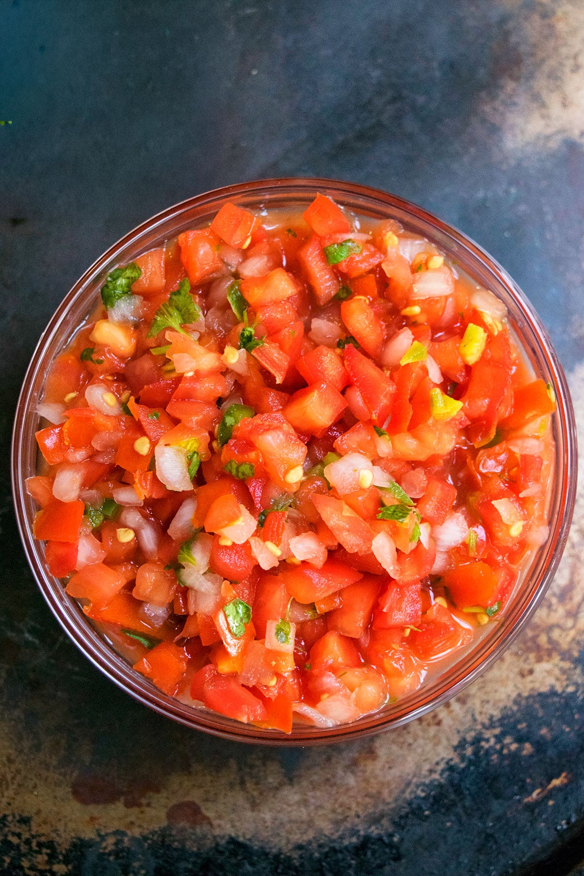 Easy homemade pico de gallo salsa in glass bowl- Overhead shot. 