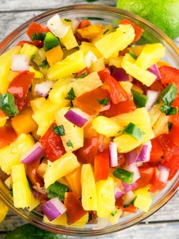 Best easy homemade pineapple salsa in glass bowl on rustic gray background.