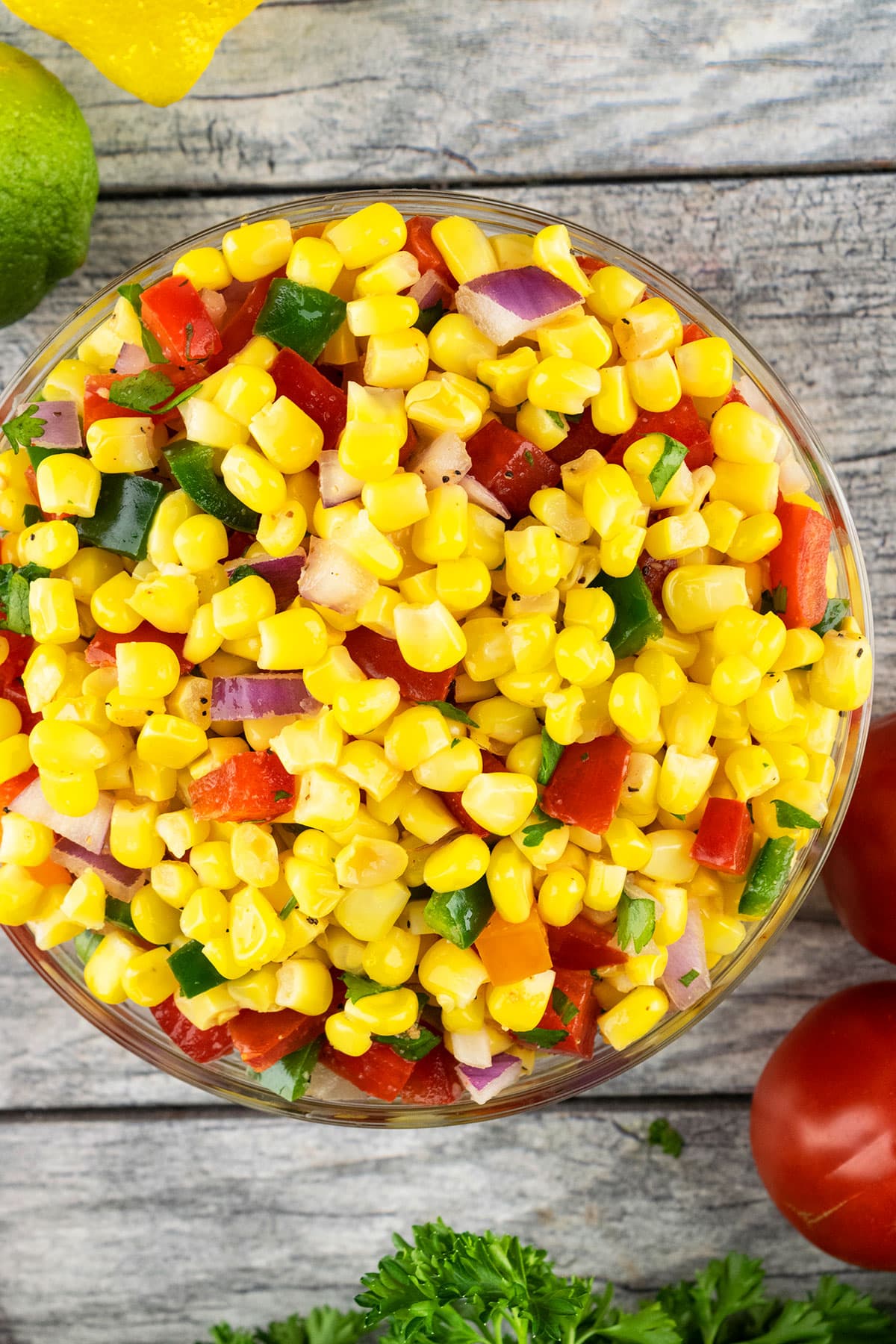 Mexican Corn Salsa in Glass Bowl on Rustic Gray Background- Overhead Shot. 