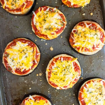 Easy baked eggplant pizza with mozzarella and cheddar cheese on baking tray.