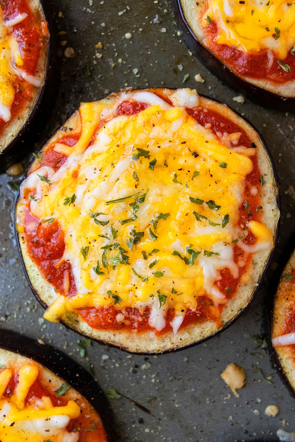 Aubergine pizza with cheese on baking tray- Overhead shot.