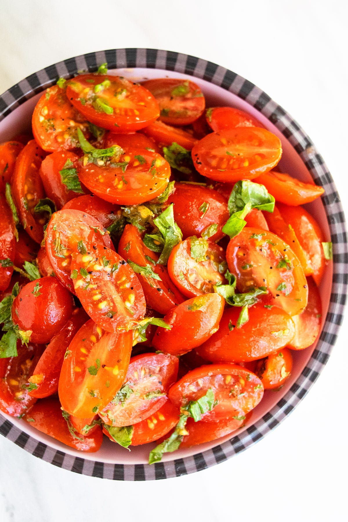 Easy homemade marinated tomatoes in black and white striped bowl- Overhead shot. 
