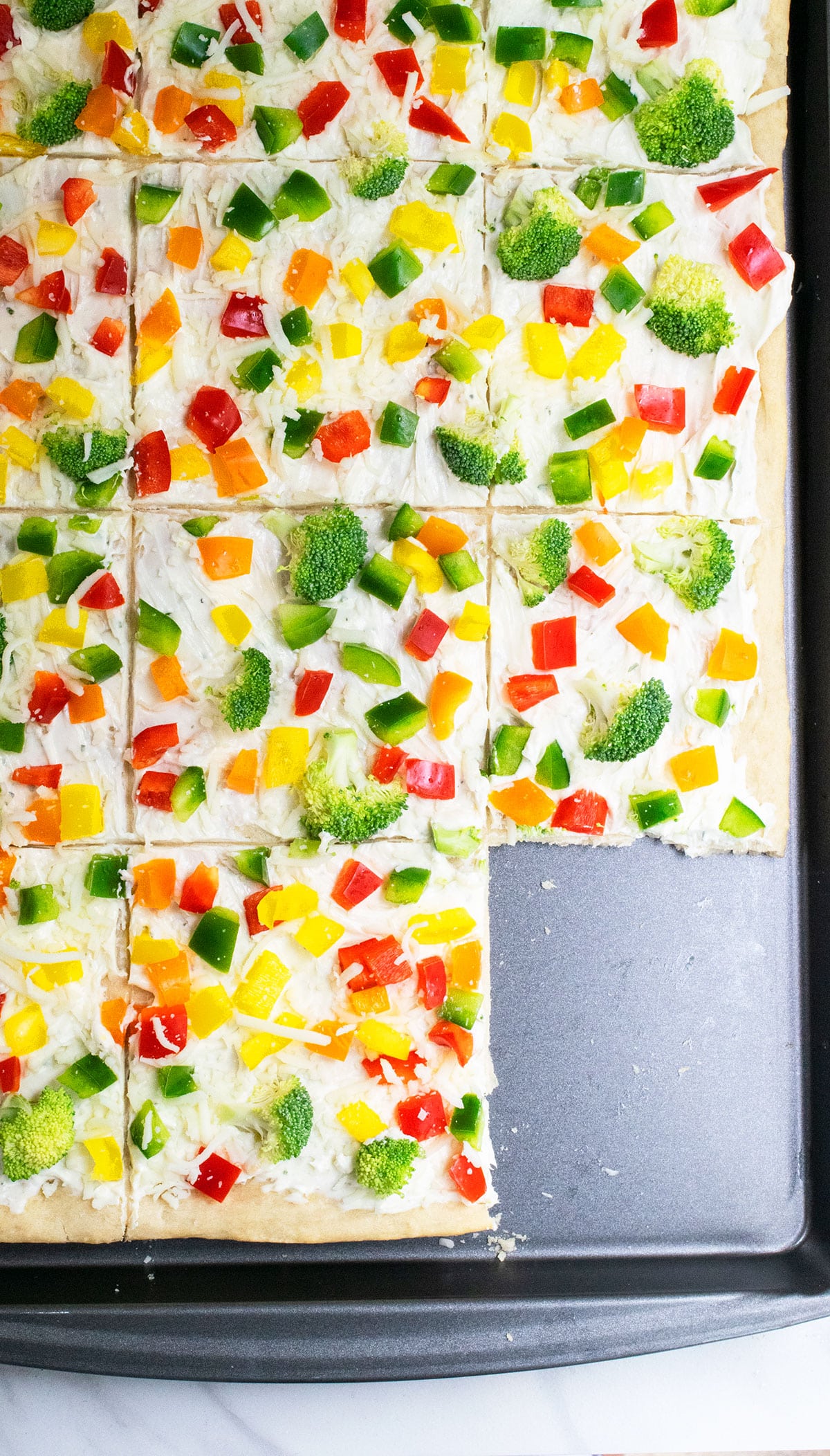 Sliced ranch pizza on nonstick baking tray. 