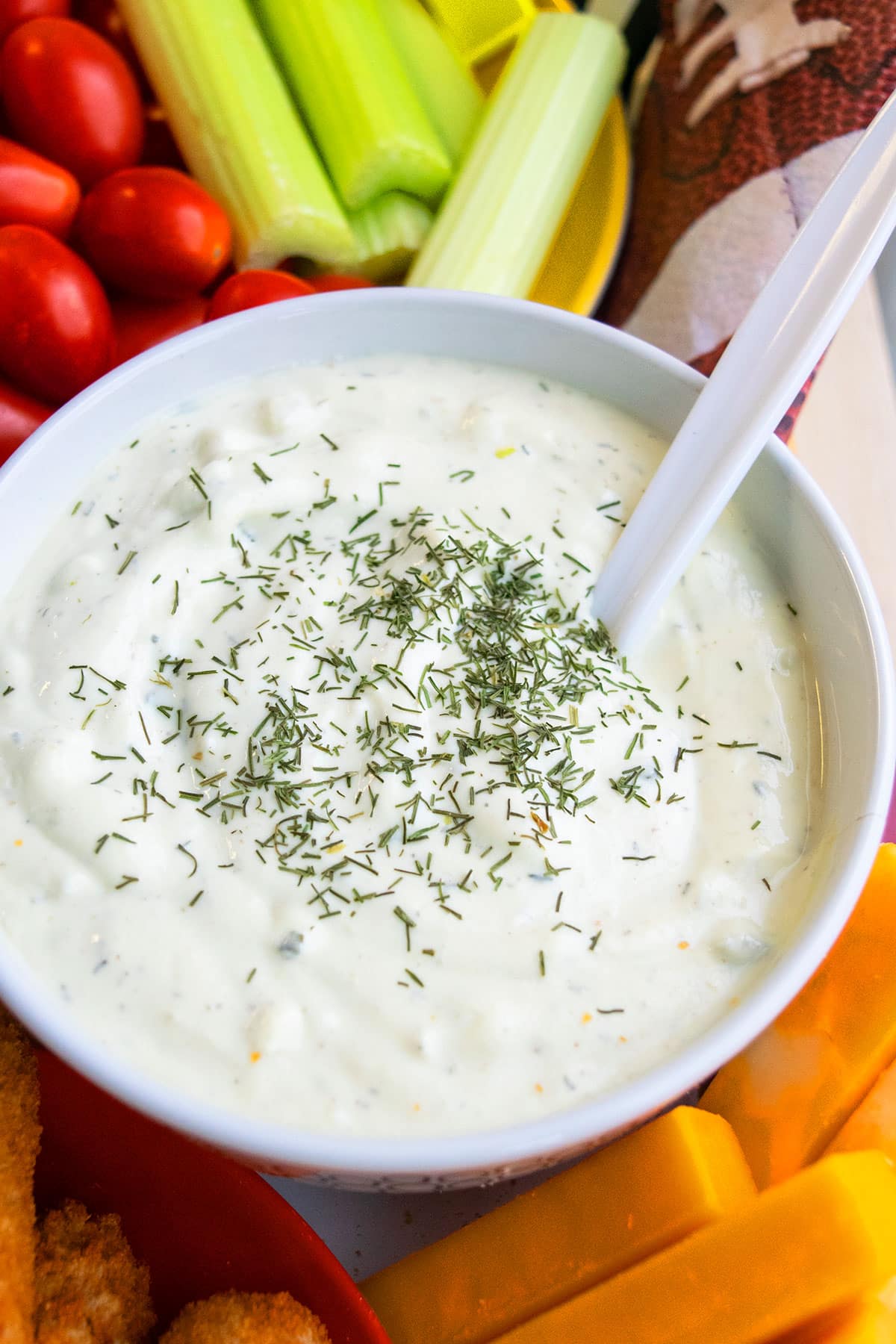 Easy creamy dill dip in white bowl with white spoon. 