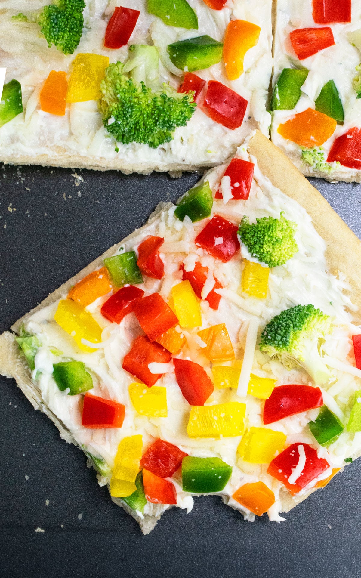 Slice of cold pizza on nonstick baking tray. 