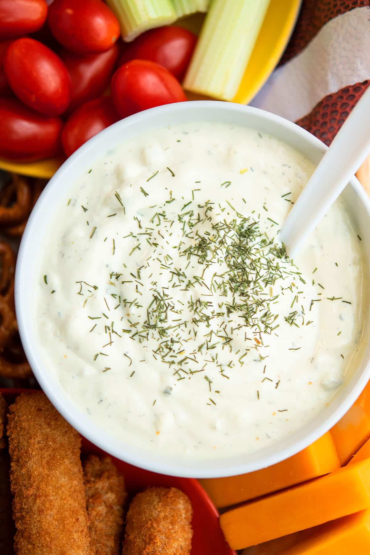 Dipping sauce in white bowl on charcuterie tray. 