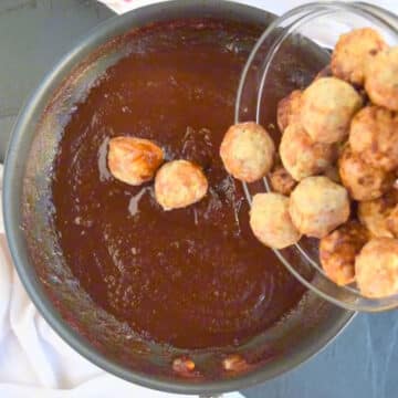 Meatballs being added to sauce. 