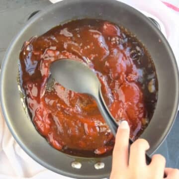 Sauce ingredients being mixed together with black spoon. 