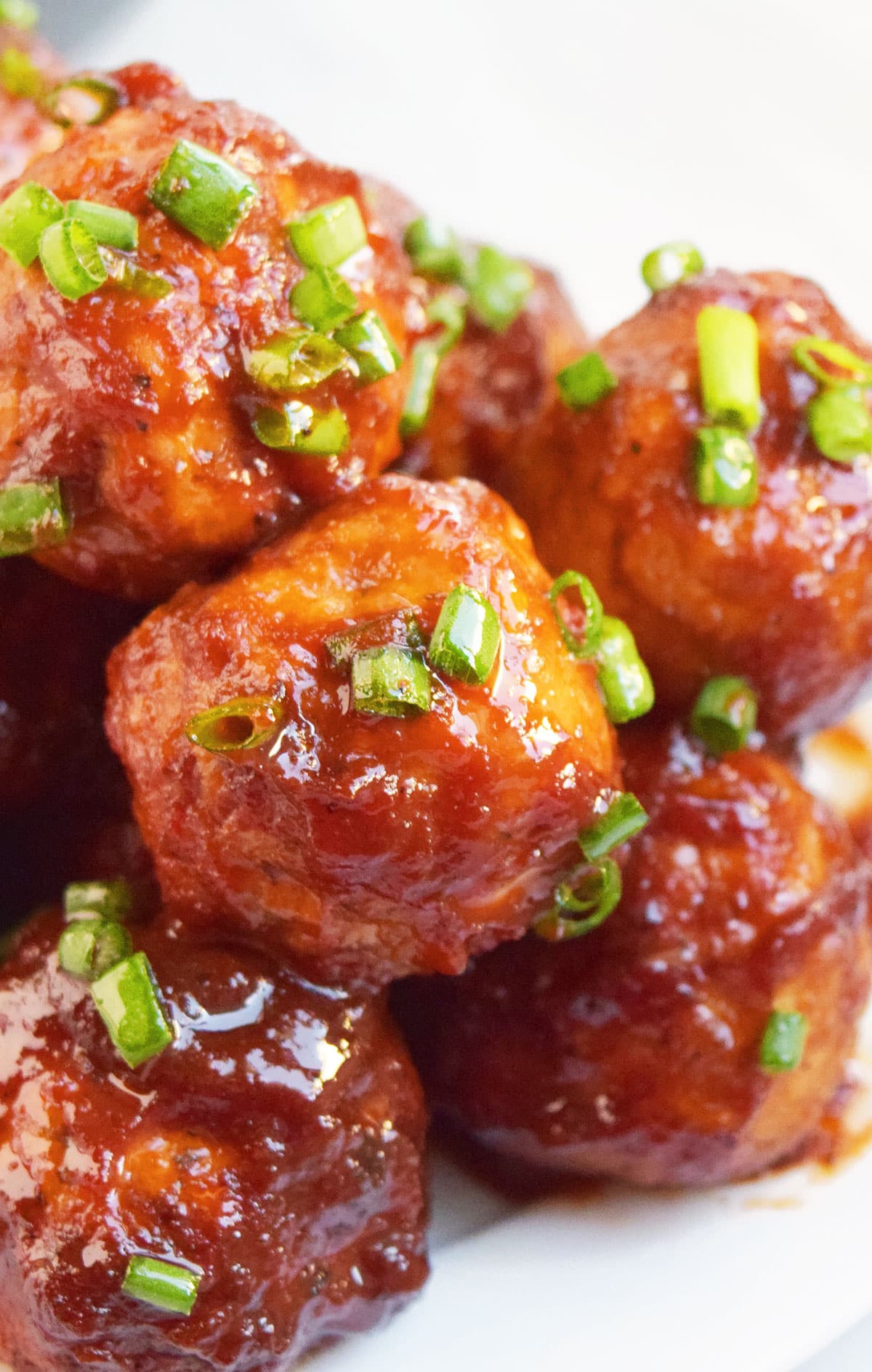 Closeup shot of cocktail meatballs or party meatballs in white dish.