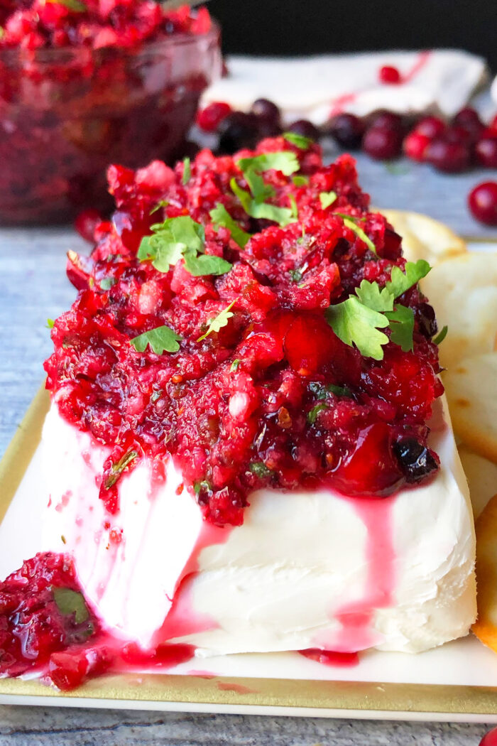 Sweet and spicy fresh cranberry salsa spooned over block of cream cheese and garnished with cilantro. 