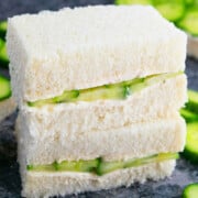 Stack of best easy one pan cucumber sandwiches (English tea sandwiches or finger sandwiches) on gray background.
