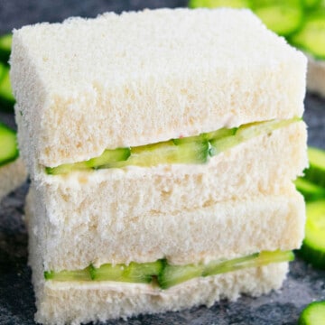 Stack of best easy one pan cucumber sandwiches (English tea sandwiches or finger sandwiches) on gray background.