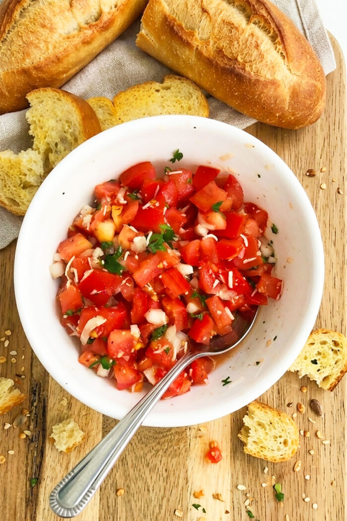 Best Tomato Topping For Bread in white bowl on rustic wood background. 