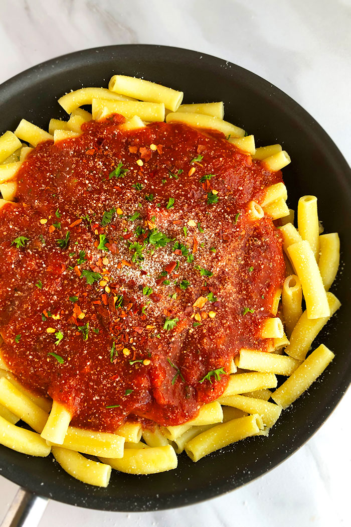 Black Pot With Penne Pasta and Arrabbiata Sauce on Top