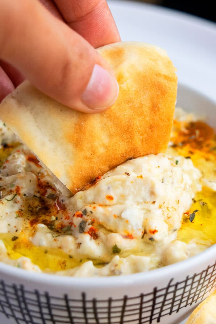 Pita Bread Being Dipped in Homemade Eggplant Dip. 