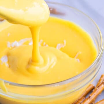 Spoonful of Homemade Cheese Sauce in a Glass Bowl.