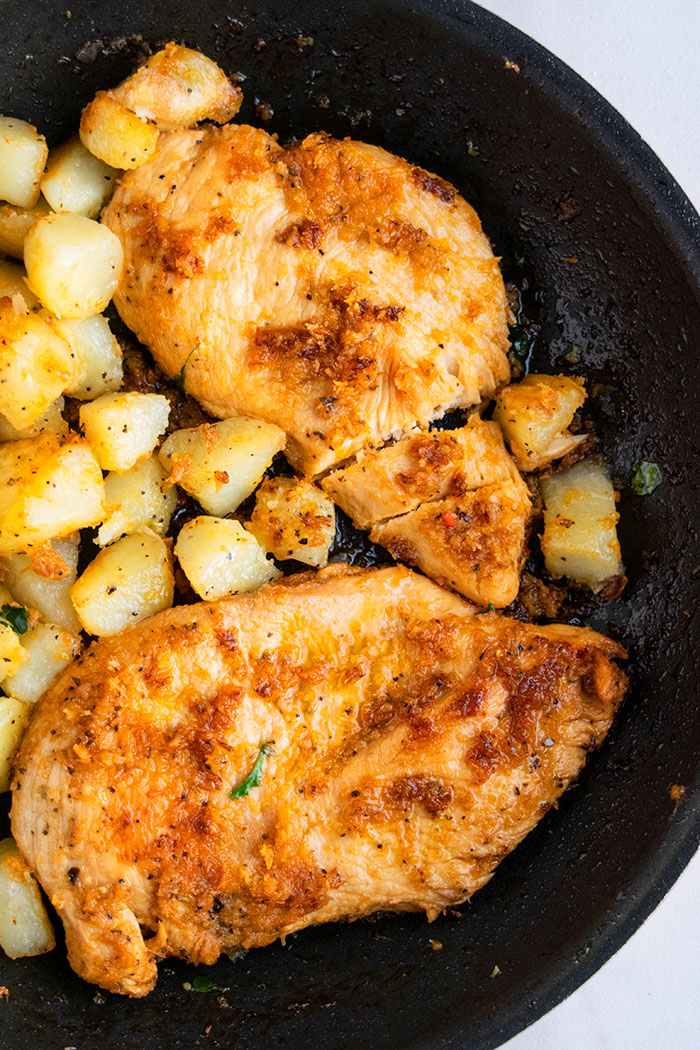 Sliced Chicken Breast and Potatoes in a Black Pan