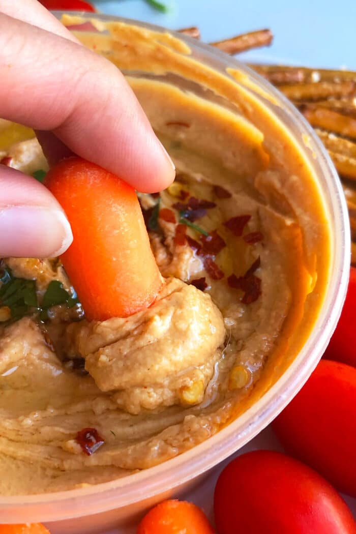 Baby Carrot Being Dipped in Dip- Closeup Shot. 