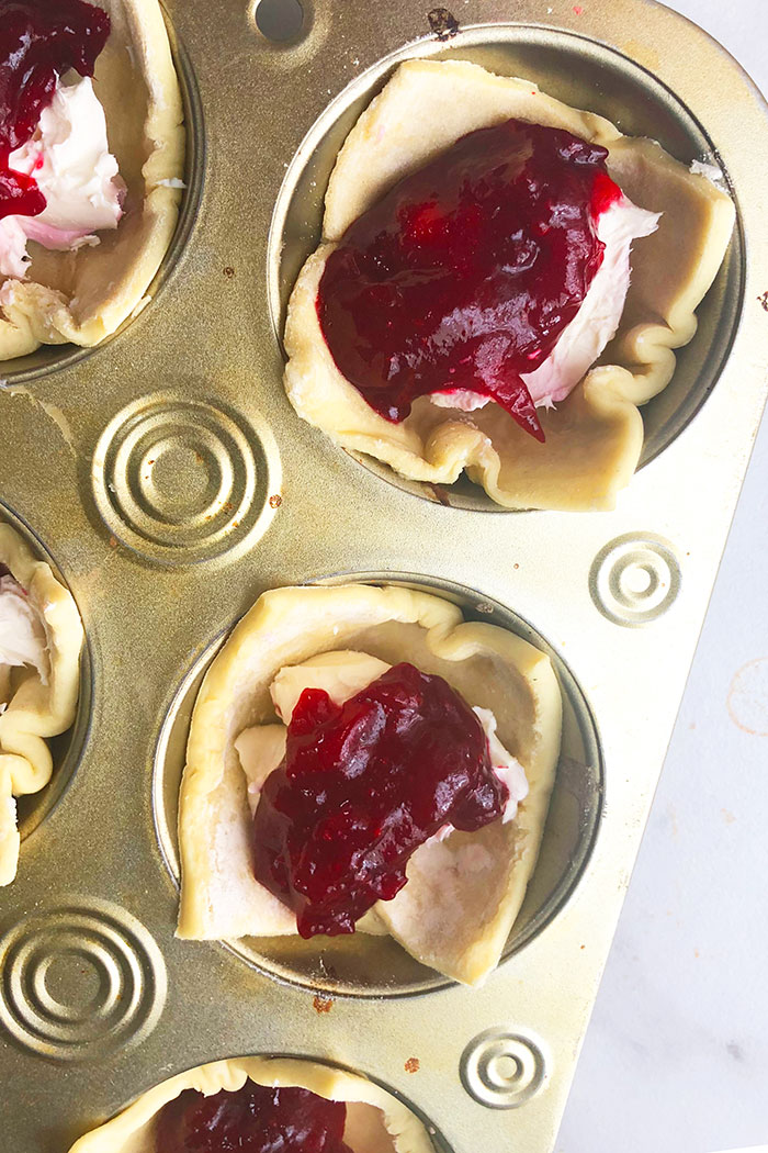 Unbaked Puff Pastry Filled with Brie Cheese and Cranberry Sauce in Cupcake Pan