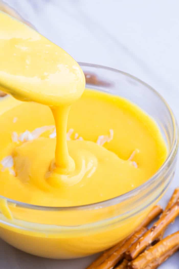 Spoonful of Homemade Cheese Sauce in a Glass Bowl 
