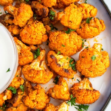 Easy Homemade Crispy Oven Baked Buffalo Cauliflower Wings on White Dish.