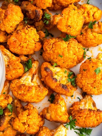 Easy Homemade Crispy Oven Baked Buffalo Cauliflower Wings on White Dish.