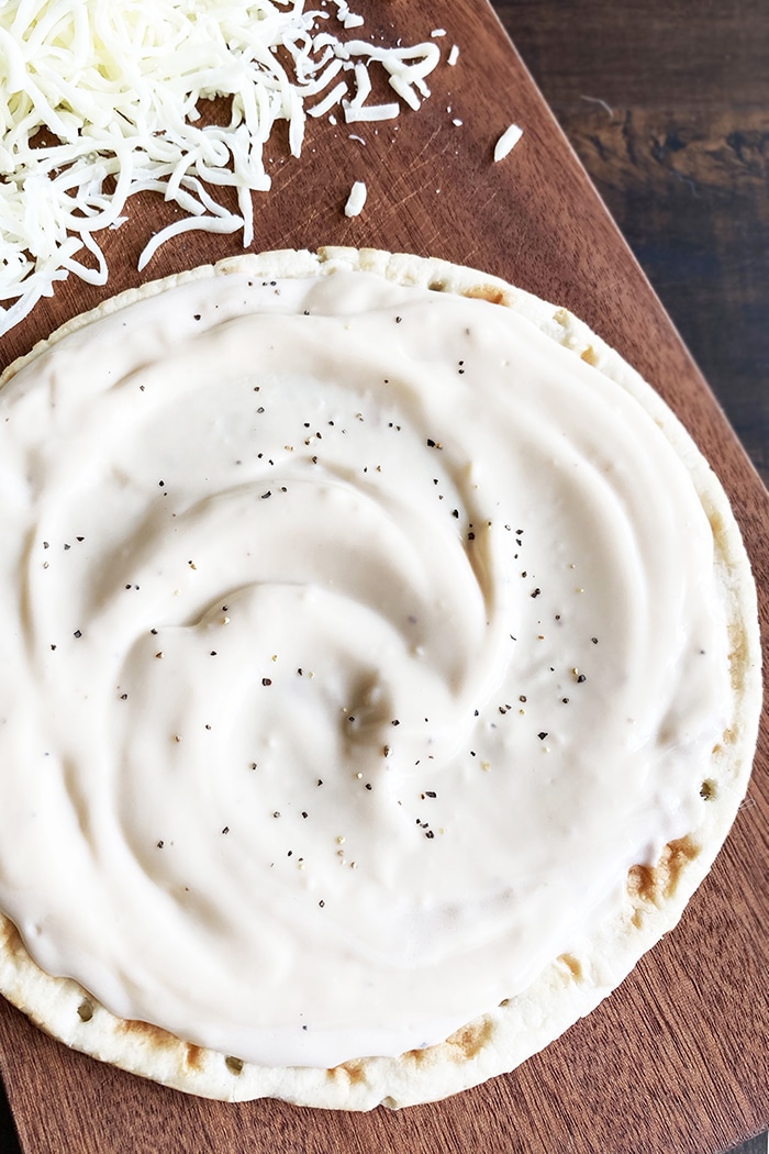 Homemade White Pizza Sauce Spread on Pizza Dough