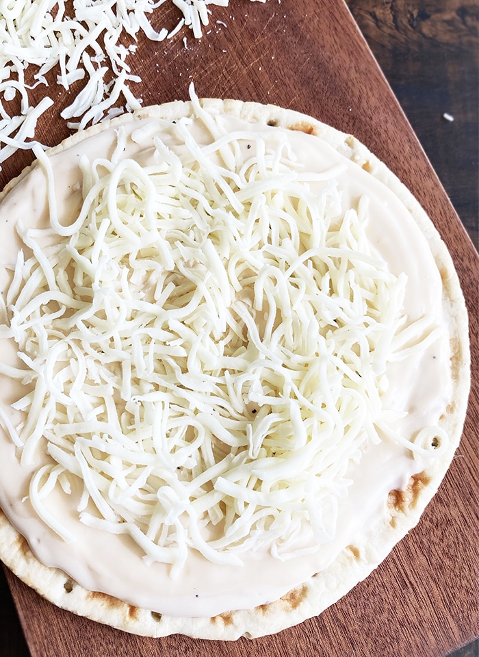 White Cheese Sauce Spread on Pizza Dough, Topped off with Shredded Cheese