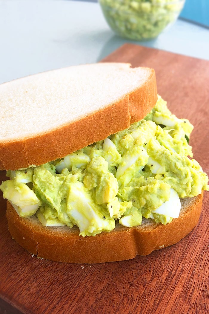 Partially Open Faced Egg Salad Sandwich on Wood Board
